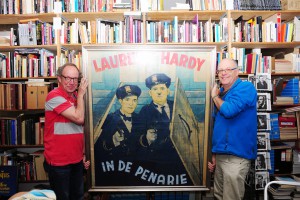 GDI-medewerkers Richard de Jong (links) en Egbert Barten met het ingelijste affiche van de Laurel en Hardy-film ‘In de penarie’.